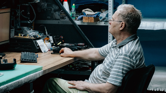 Een man (die ouder is dan de AOW-leeftijd) is aan het werk achter een laptop.