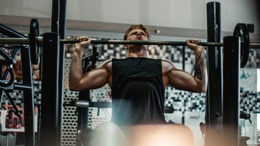 Een man die aan het sporten is in de sportschool