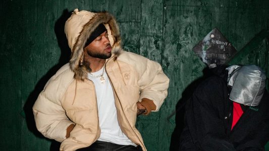 Een man draagt een jas uit de wintercollectie van Supreme en Timberland