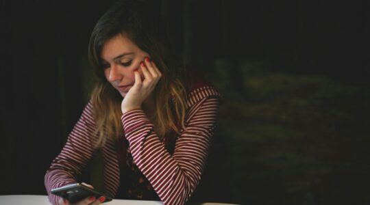 Een vrouw die op haar telefoon kijkt
