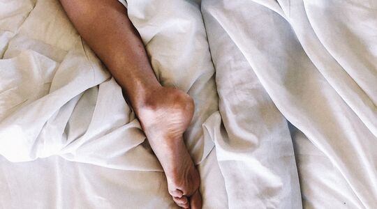 Iemand die op zondagochtend te lang in bed blijft liggen