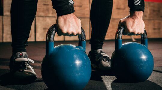 Een man die met kettlebells aan het trainen is