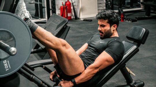 Man in de sportschool die traint, mogelijk gericht op afvallen en het behouden van spiermassa