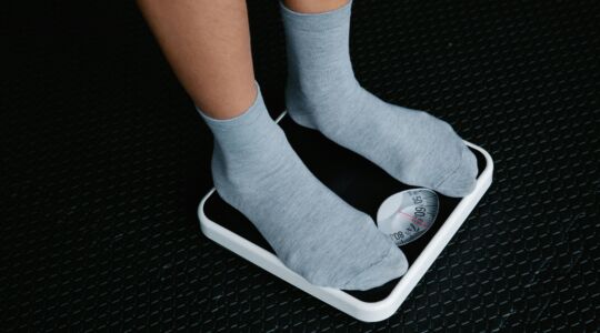 De voeten van een man die op de weegschaal staat