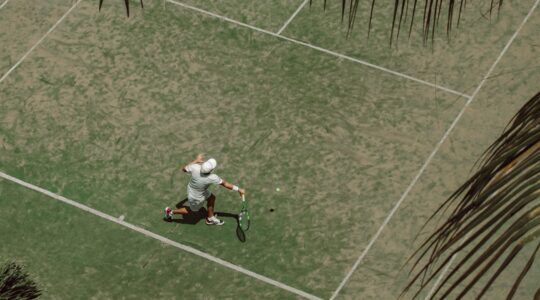 Iemand die aan het tennissen is op het gras van Wimbledon en hopelijk niet zijn racket kapotgooit