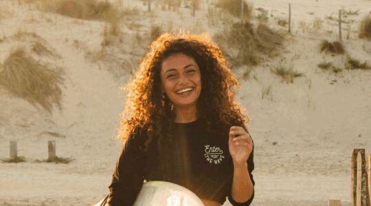 Joël van Leeuwaarde op het strand met surfbord