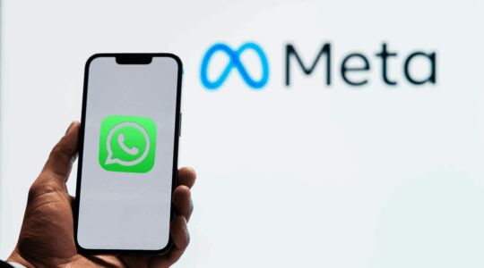 Telefoon in hand met chatdienst WhatsApp op beginscherm.