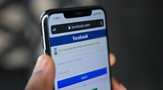 Een smartphone met de app van Facebook, welke jouw foto's ook gaat gebruiken voor AI