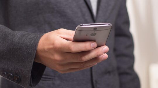 Nederlandse man die op zijn telefoon op een dating app zit, waarna hij wordt opgelicht