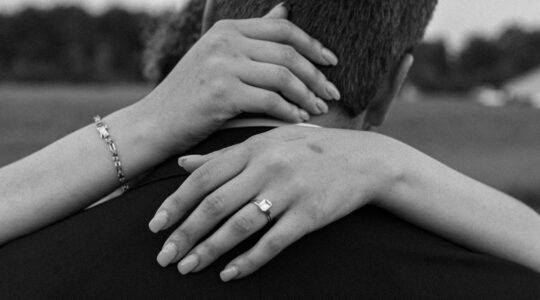 Een koppel intiem met elkaar, waarbij de vrouw een ring om haar vinger draagt