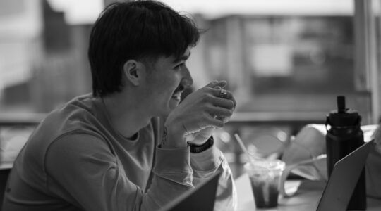 Een man die achter zijjn laptop zit voor zijn deeltijd hbo-opleiding