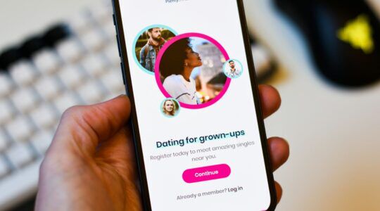 Een hand met een smartphone met een datingapp