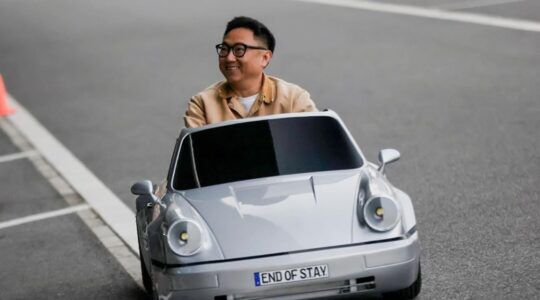 Man die in een mini Porsche rijdt