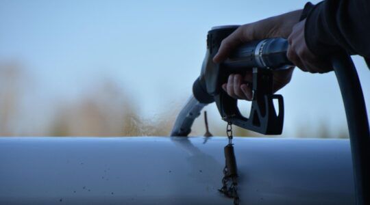 Een pomp in de hand bij een auto