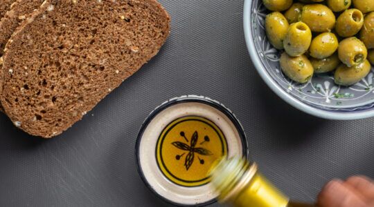 Iemand schenkt olijfolie in een bakje