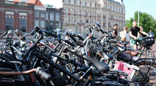 Een hoop fietsen geparkeerd in een stalling
