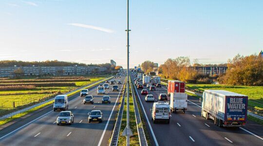 Auto's rijden op een Nederlandse snelweg, waarbij sommige voertuigen langzamer rijden (misschiel wel dem minimale snelheid) dan de rest van het verkeer.