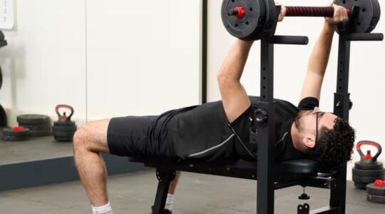 Man die sport op de inklapbare, verstelbare halterbank van Action