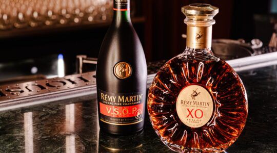 Twee flessen Rémy Martin cognac op een bar, klaar om geserveerd te worden in een luxe setting