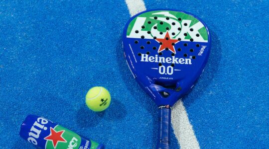 Tennis raket met tennisballen en Heineken blik