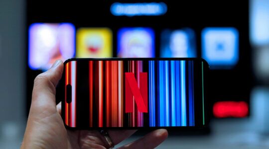 Een persoon houdt een telefoon vast met Netflix