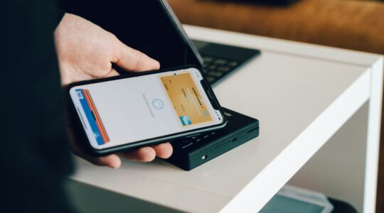 Digitale euro, een man betaalt met zijn pinpas via zijn telefoon