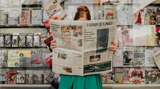 Een vrouw die de krant aan het lezen is