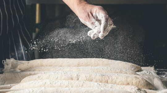 Een bakker die bezig is met het bereiden van brood