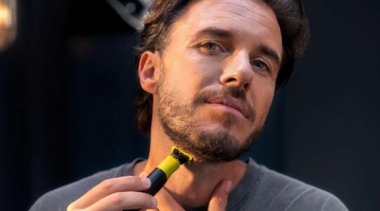 Een man die met een OneBlade zijn baard aan het bijwerken is