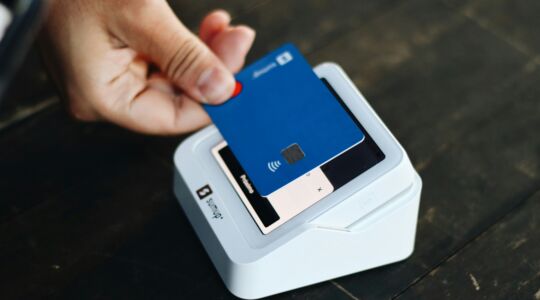 Een man pint voor een aankoop bij een pinautomaat