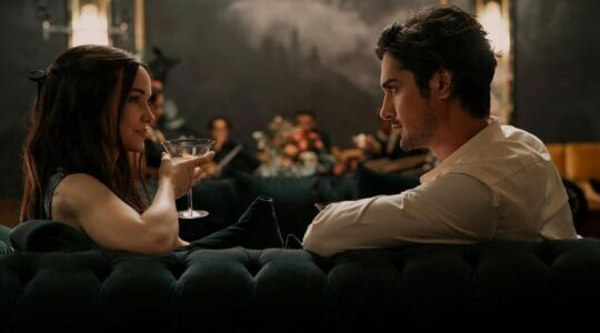 Een man en vrouw die op de bank zitten met een drankje