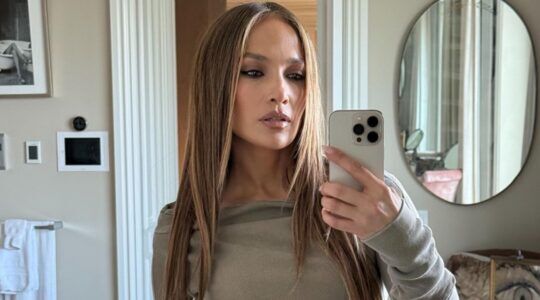 Jennifer Lopez die een foto maakt in een spiegel.