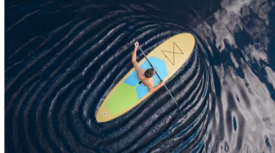 Het opblaasbare supboard op water.