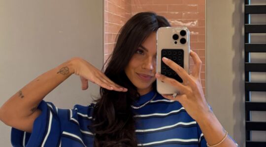 Een spiegelselfie van een vrouw in de badkamer.
