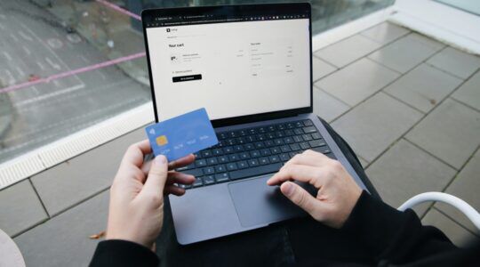 Persoon die wellicht het rekeningnummer van de Belastingdienst aanpast via een laptop.