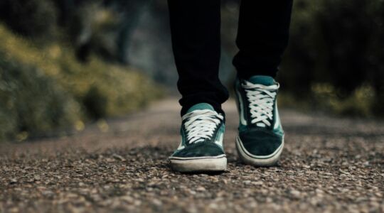 De schoenen van een man die stappen zet