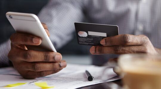Een man die wellicht onterecht afgeschreven geld probeert terug te boeken via zijn smartphone.