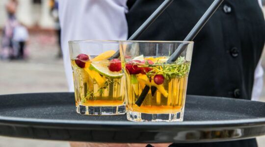 Serveerster met drank op een dienblad.