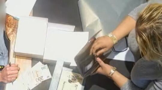 Een vrouw die aan tafel zit om een Rolex te stelen.