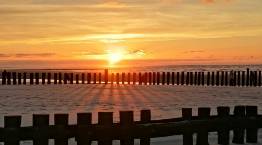 Een zonsondergang op het strand.