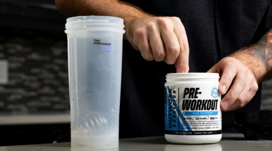 Iemand die pre-workout in een beker doet.