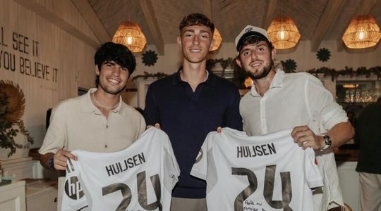 Dean Huijsen met zijn eigen shirts op de foto.