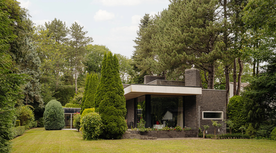 Een designvilla omringd door veel groen.