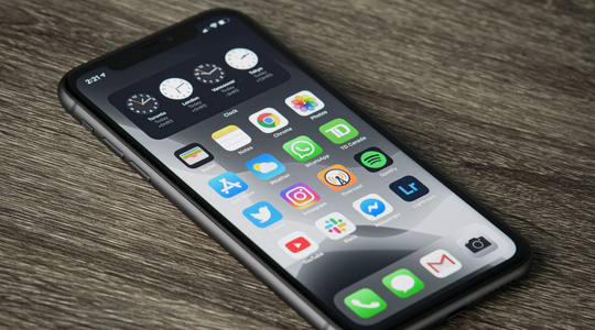 Een telefoon met apps die op tafel ligt.