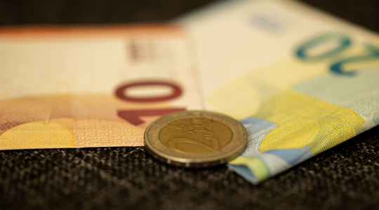 Twee geldbriefjes en een 2-euromunt
