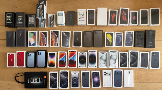 Een verzameling van 54 iPhones die op een tafel ligt.