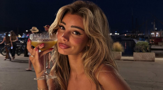Laura Celia die een glas vast heeft.