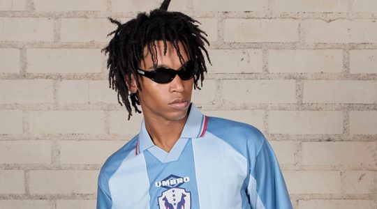 Iemand draagt de Umbro X Pleasures Retro collectie