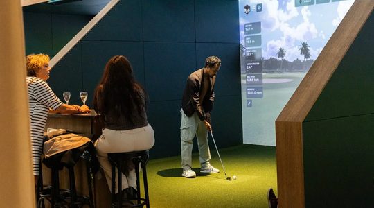 Een man die virtueel aan het golfen is bij Club Birdies in Amsterdam